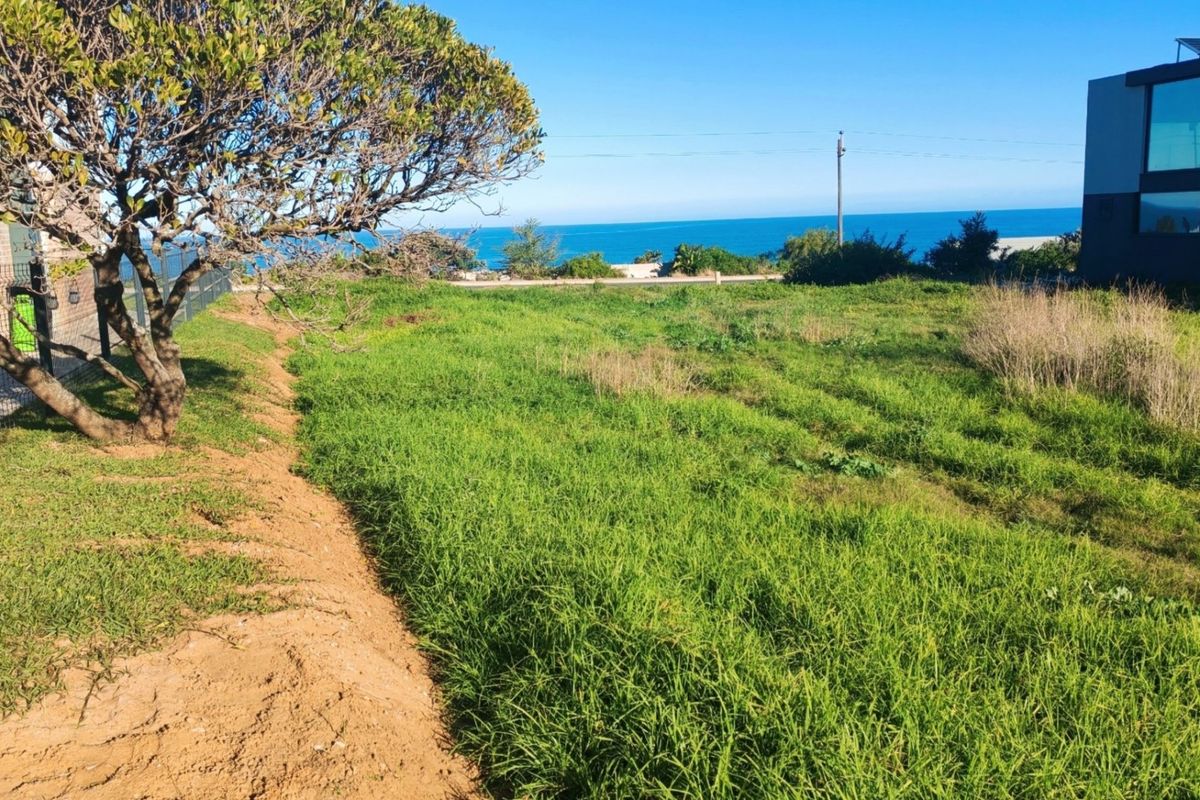 A vacant residential plot featuring natural grass coverage and scenic coastal views, offering potential for future development.