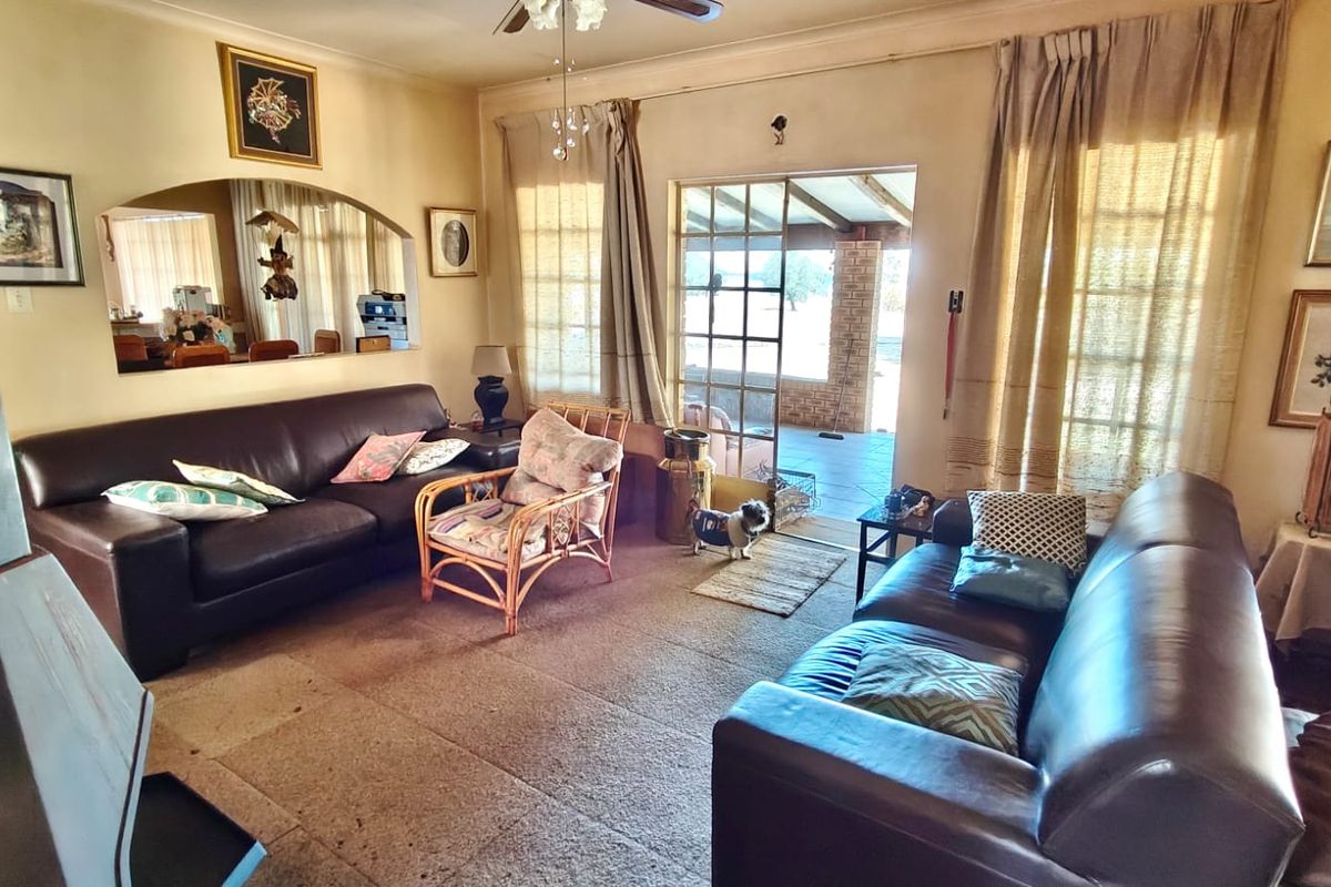 A living room featuring a fireplace, ceiling fan, and sliding glass door access to an outdoor patio area.
