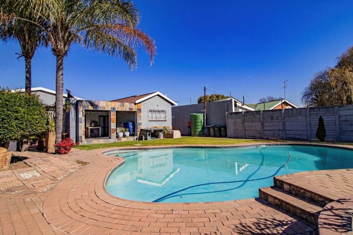 Outdoor pool area featuring a swimming pool, brick paved surround, and perimeter walling, set within a private rear garden space.