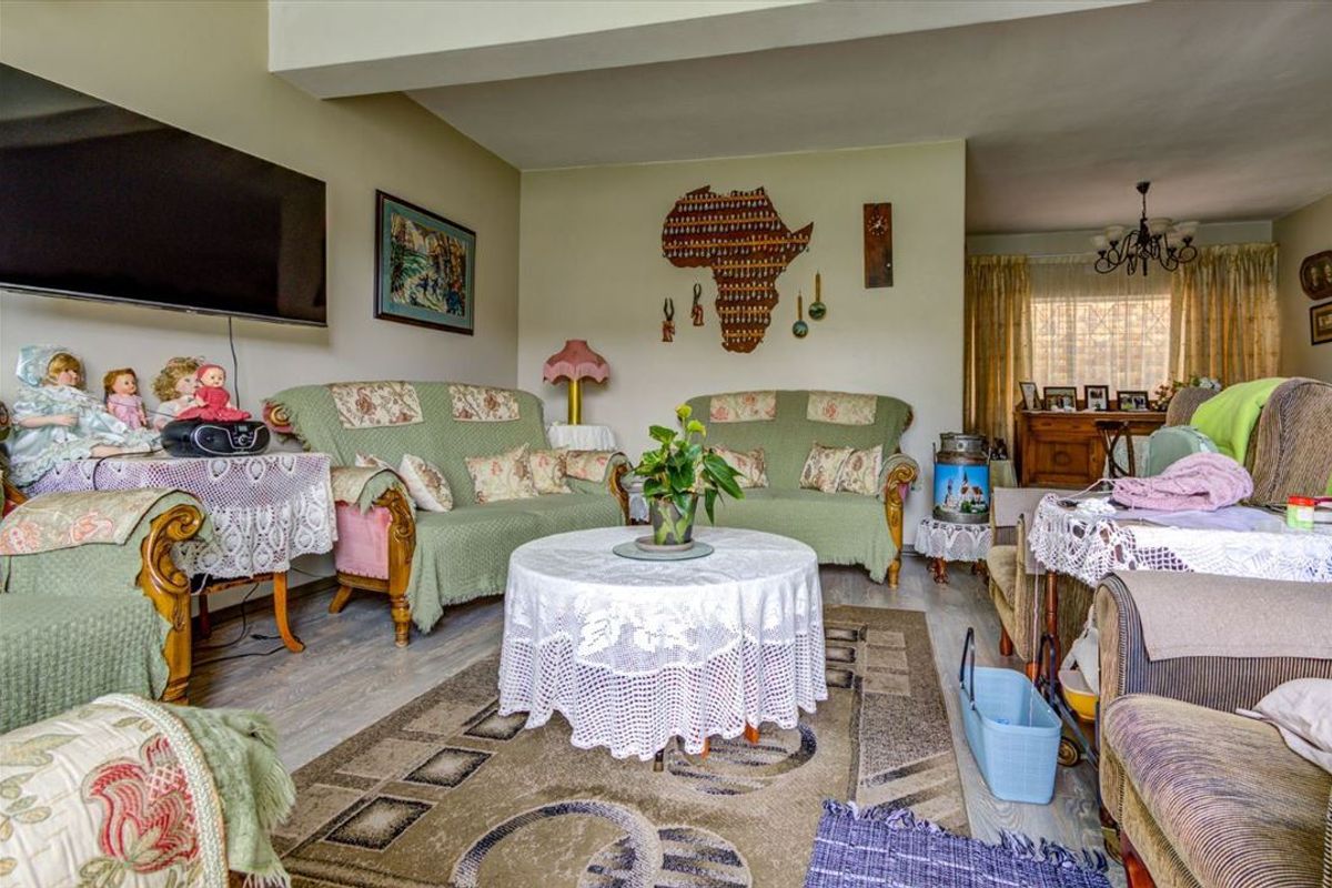 A spacious living room featuring laminate flooring and neutral wall finishes, offering a comfortable and functional layout for relaxation.