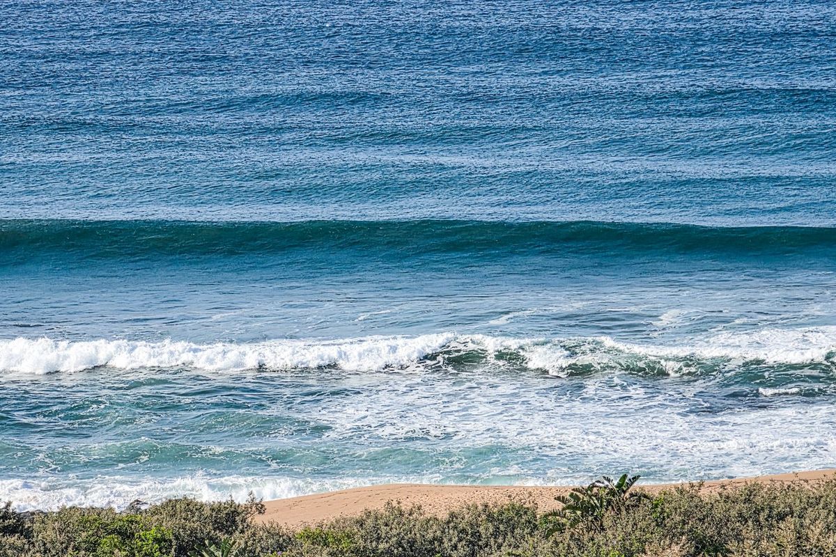 A scenic view of the ocean, waves, and sandy coastline, highlighting the natural beauty and proximity to the beach.