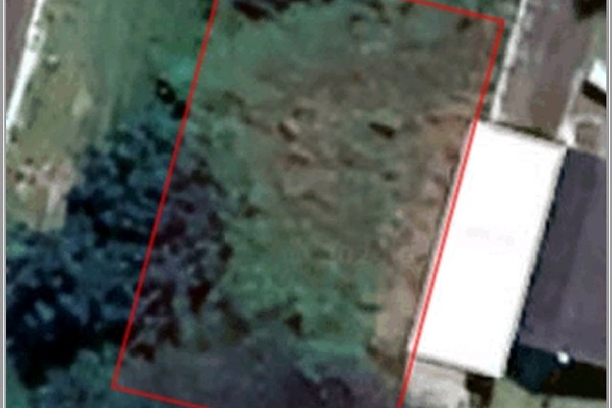 Aerial view of a vacant residential plot with defined boundary lines.