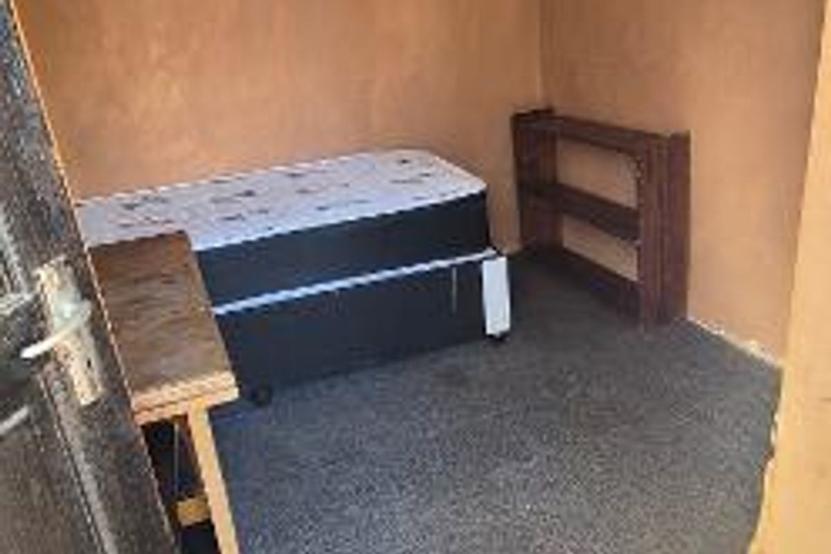 A small bedroom featuring carpeted flooring and textured wall finishes, offering a blank canvas for potential renovation and interior design updates.