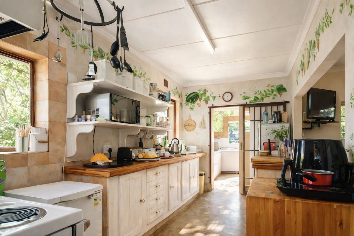 A functional kitchen featuring wooden countertops, open shelving, and built-in cabinetry, with a sliding door leading to an adjacent utility area.