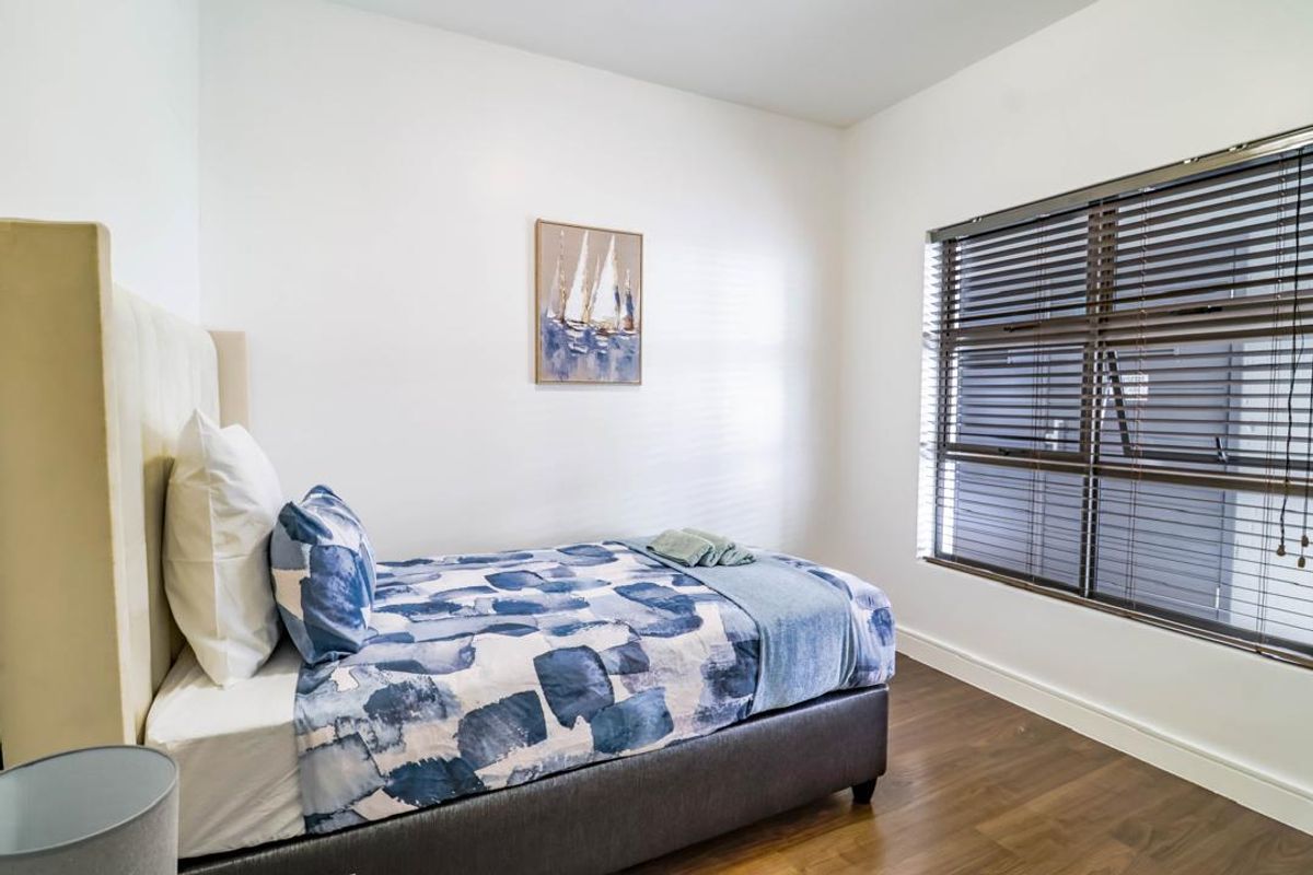 A well-maintained bedroom featuring laminate flooring, neutral walls, and venetian blinds, providing a clean and comfortable living space.