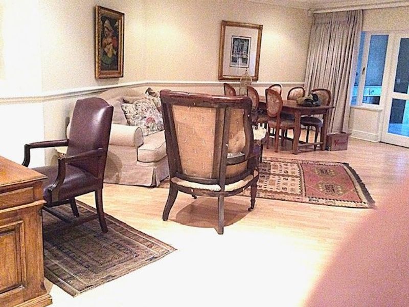 Open plan living and dining area featuring timber flooring, chair rail molding, and access to an outdoor space via sliding glass doors.