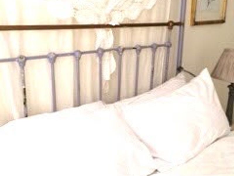 A close-up view of a bedroom space featuring a metal bed frame and window treatments.