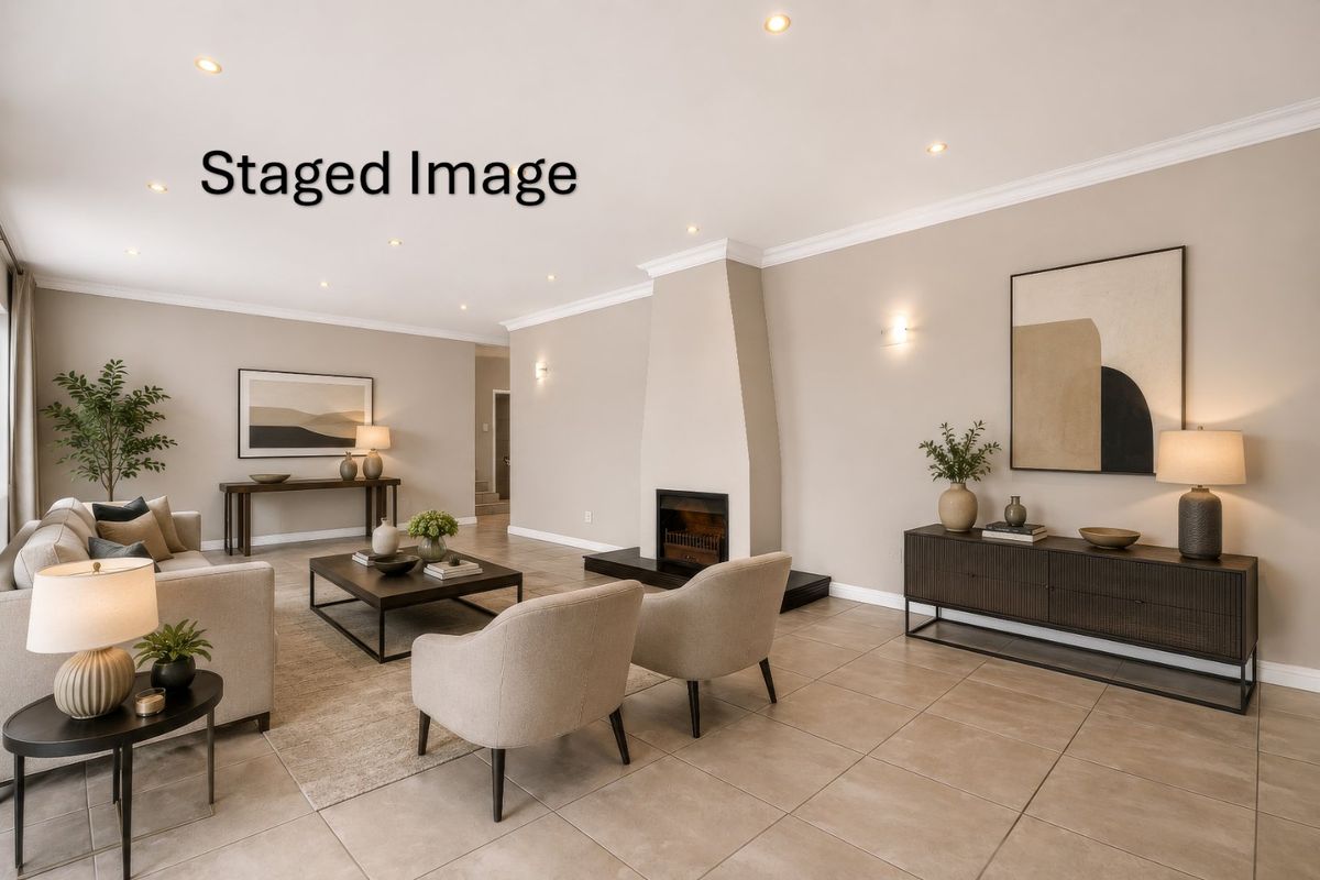 Spacious living room featuring a central fireplace, neutral tiled flooring, and modern recessed lighting with elegant wall sconces.