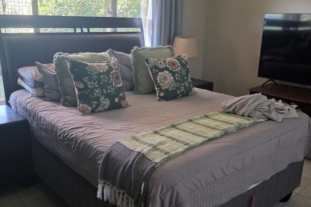A functional bedroom featuring tiled flooring and natural light from the window.