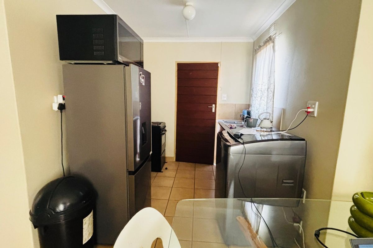 A functional kitchen area featuring tiled flooring and a neutral color palette, providing a practical space for daily meal preparation and household tasks.