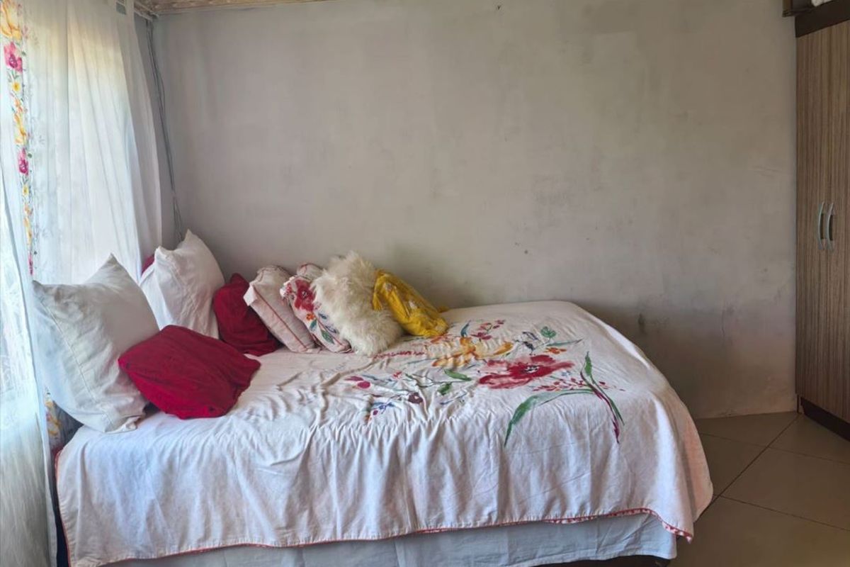 A bedroom featuring tiled flooring, a built-in wardrobe, and decorative ceiling cornice, requiring cosmetic wall repairs and updates.