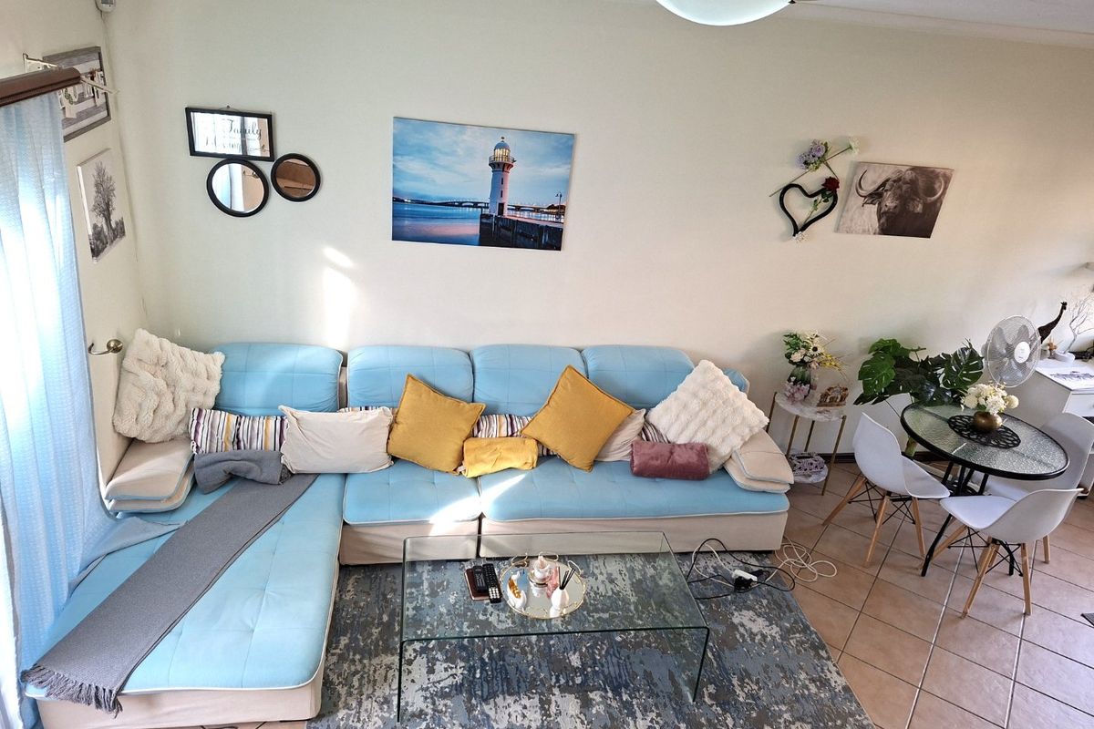 A bright living room area featuring ceramic tile flooring and a central flush mount ceiling light, providing a functional and comfortable living space.