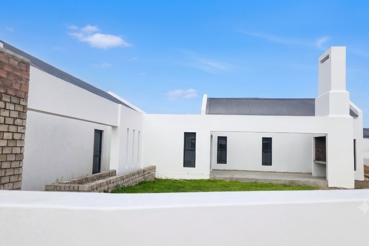 Rear view of a modern home featuring a covered patio with a built-in braai, concrete flooring, and a clean white exterior finish.