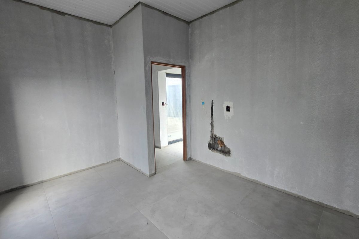 An unfinished bedroom interior featuring tiled flooring and plastered walls, currently requiring final finishes and electrical repairs.