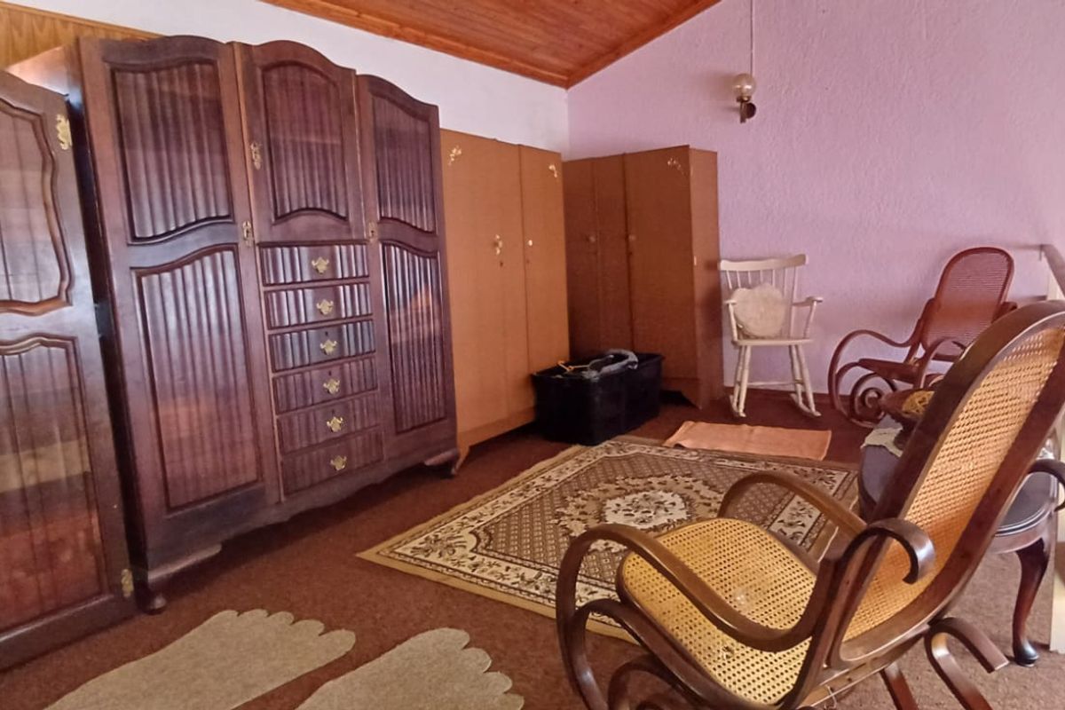 A loft-style bedroom area featuring a timber ceiling, timber balustrade, and carpeted flooring.