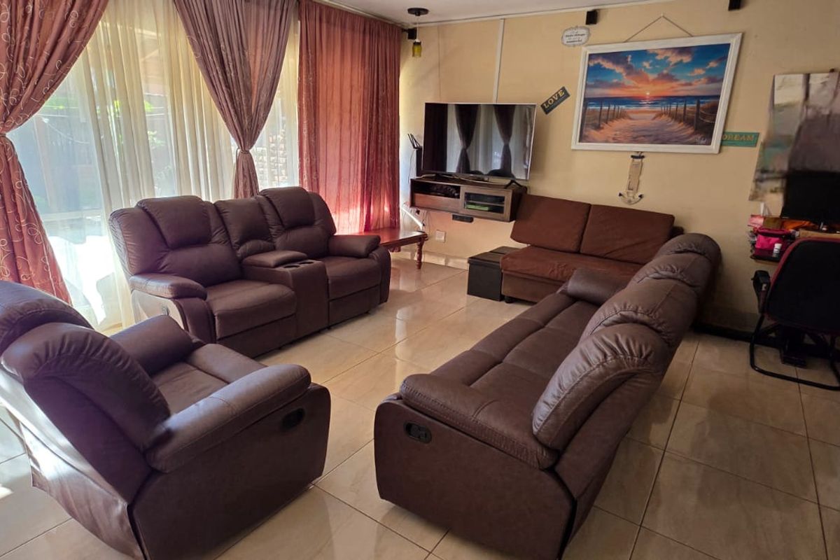 A living room featuring tiled flooring and a large sliding glass door that provides access to the exterior.