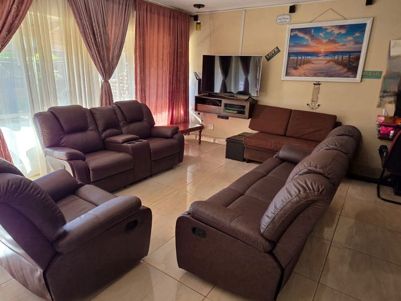 A living room featuring tiled flooring and a large sliding glass door that provides access to the exterior.