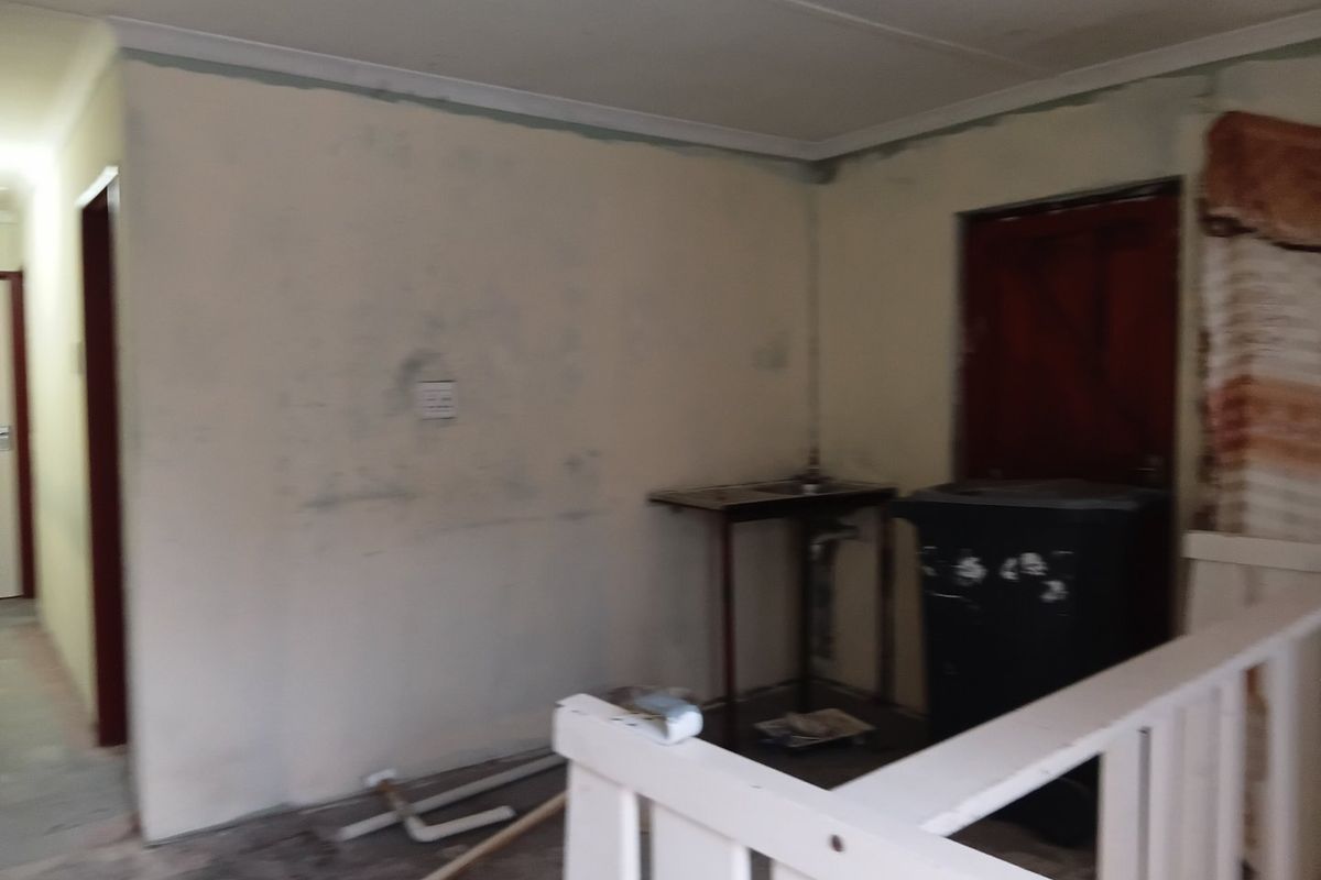 An unfinished kitchen area featuring basic plumbing connections and exposed wall surfaces, requiring renovation to become a functional space.