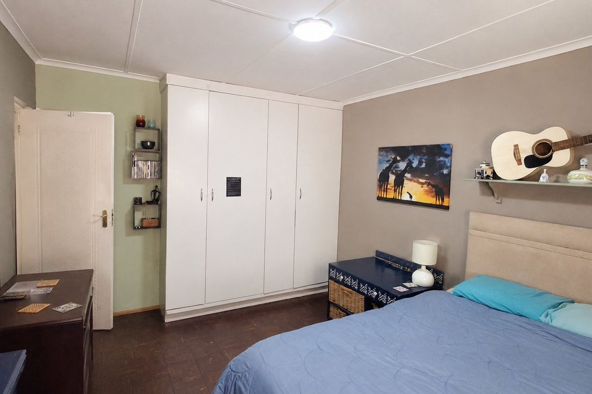 A functional bedroom featuring built-in cupboards and neutral wall finishes, providing a comfortable and practical living space.