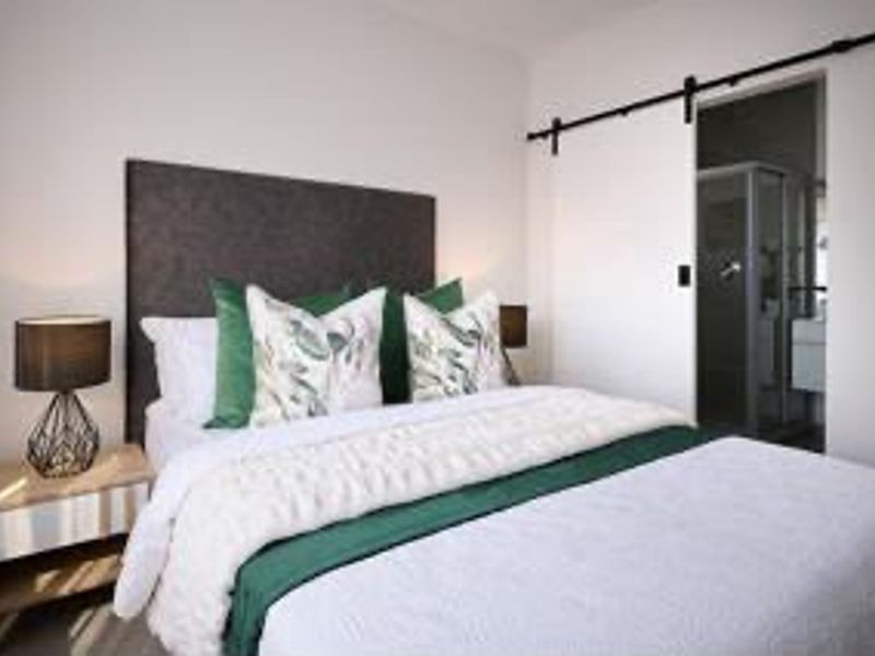 A well-presented bedroom featuring a modern sliding barn door providing direct access to an en-suite bathroom.