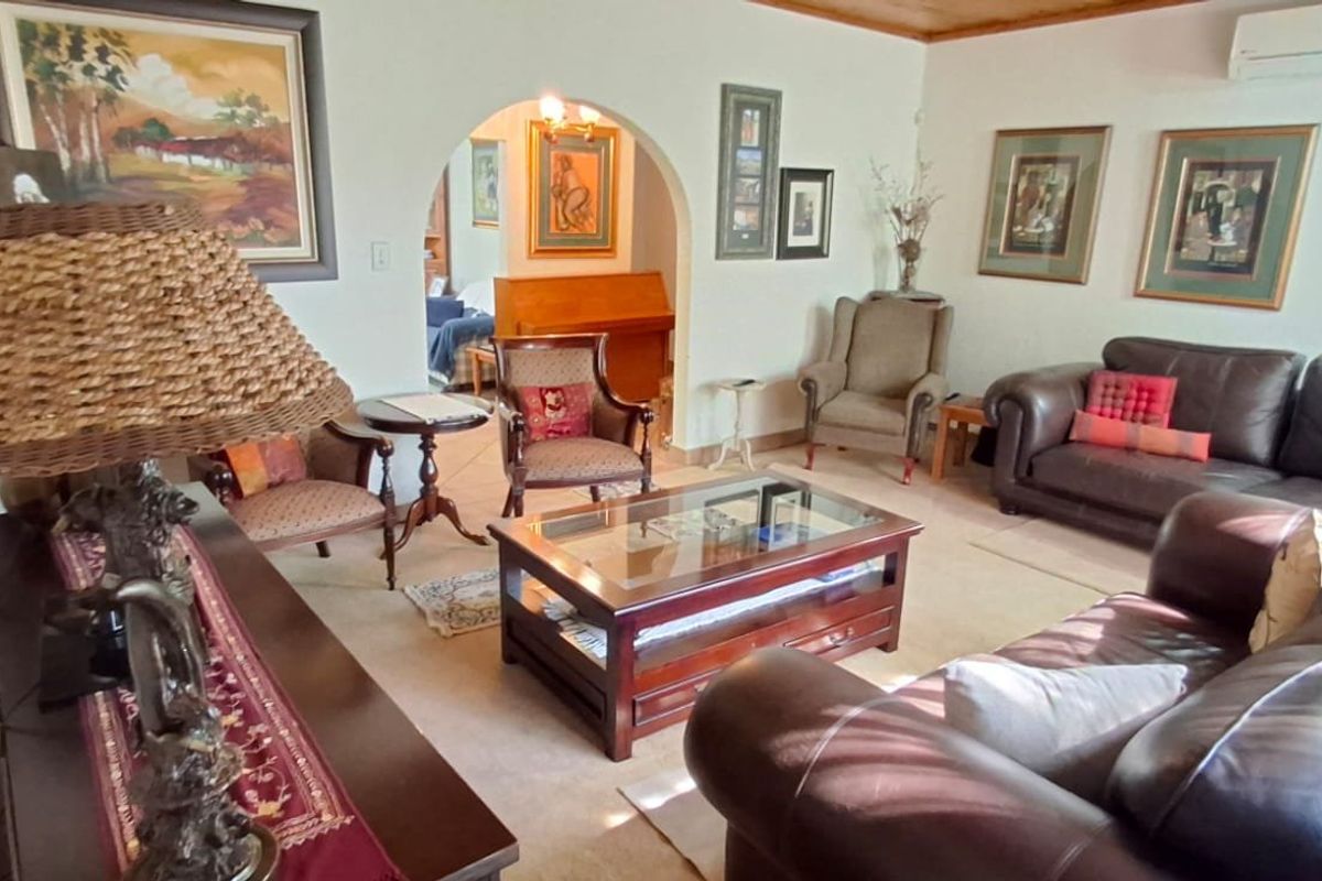 A comfortable living room featuring an arched entryway leading to an adjacent space and a wall-mounted split-system air conditioning unit.