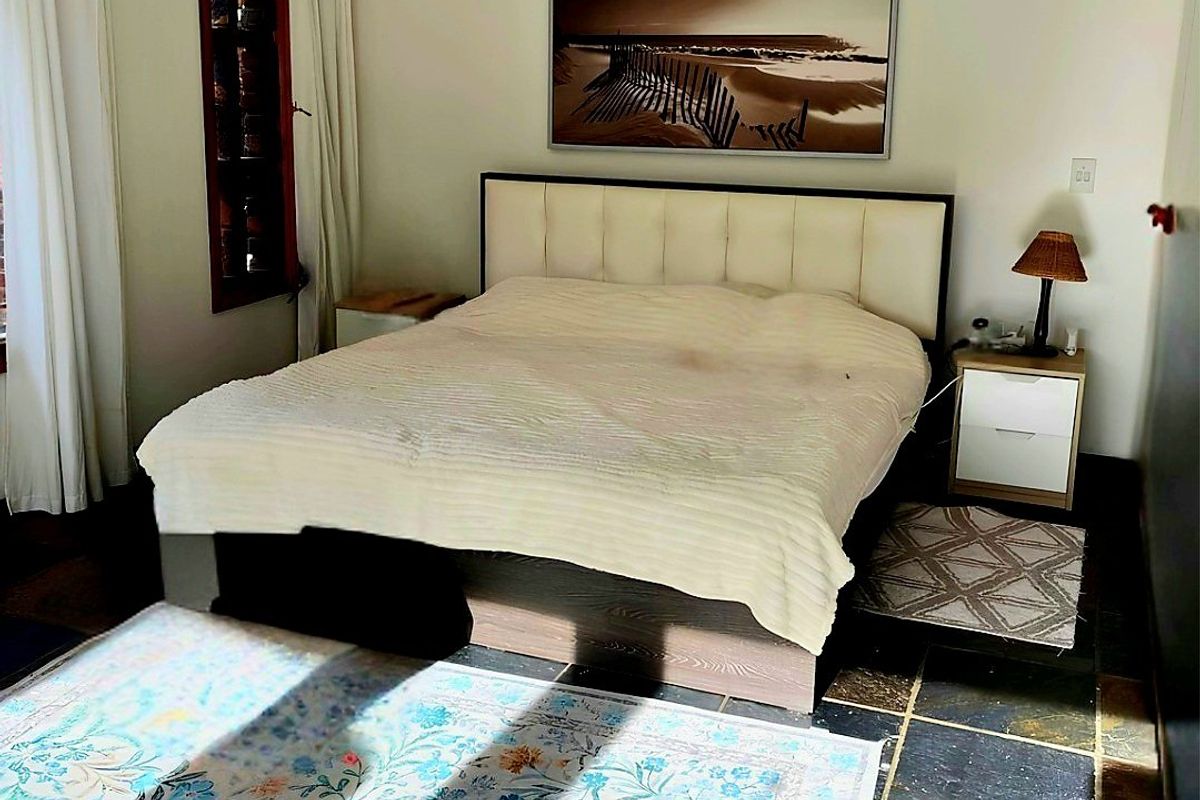 A bedroom featuring natural slate tile flooring and ventilation grilles, offering a neutral base ready for updated styling and finishes.