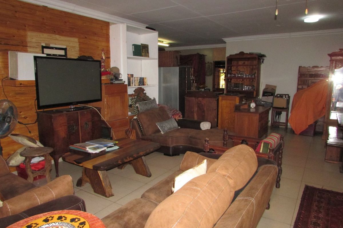 Spacious living area featuring tiled flooring, built-in shelving, and a ceiling fan, offering a versatile layout for comfortable family living.