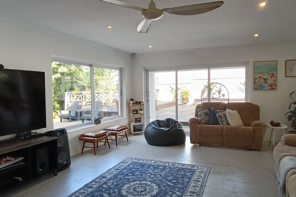 Spacious living room featuring polished concrete floors, recessed lighting, a ceiling fan, and large sliding glass doors providing access to the outdoor area.