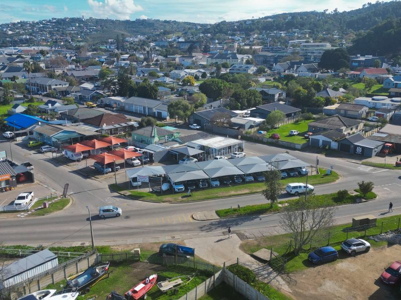 Aerial view of a commercial property featuring multiple shade cloth carports and paved parking areas situated within a suburban neighborhood.