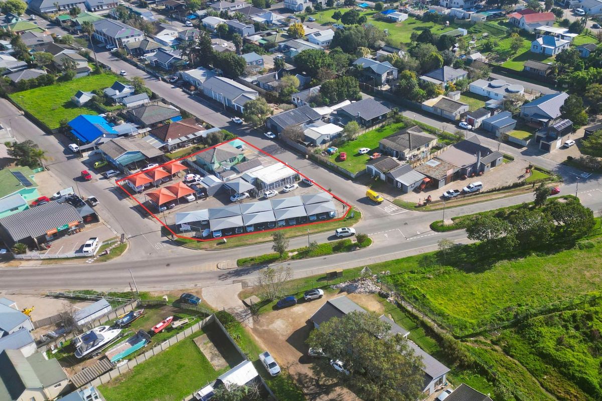 Aerial view of a commercial property featuring a paved parking lot with multiple shade cloth carports and surrounding building structures.