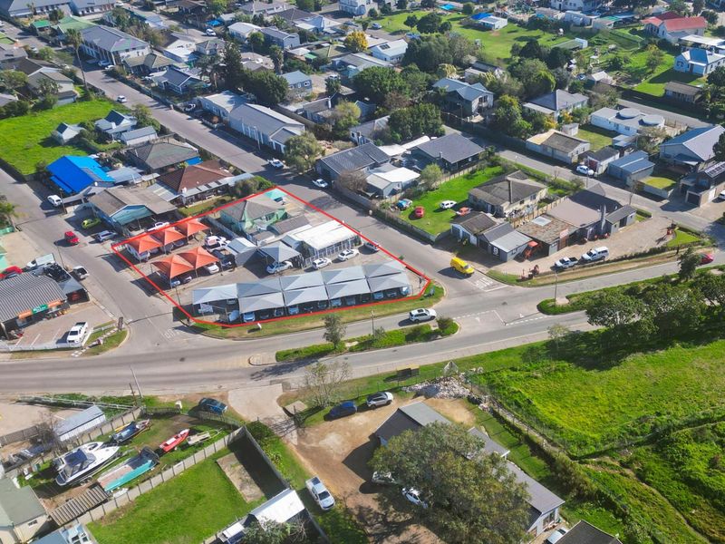 Aerial view of a commercial property featuring a paved parking lot with multiple shade cloth carports and surrounding building structures.