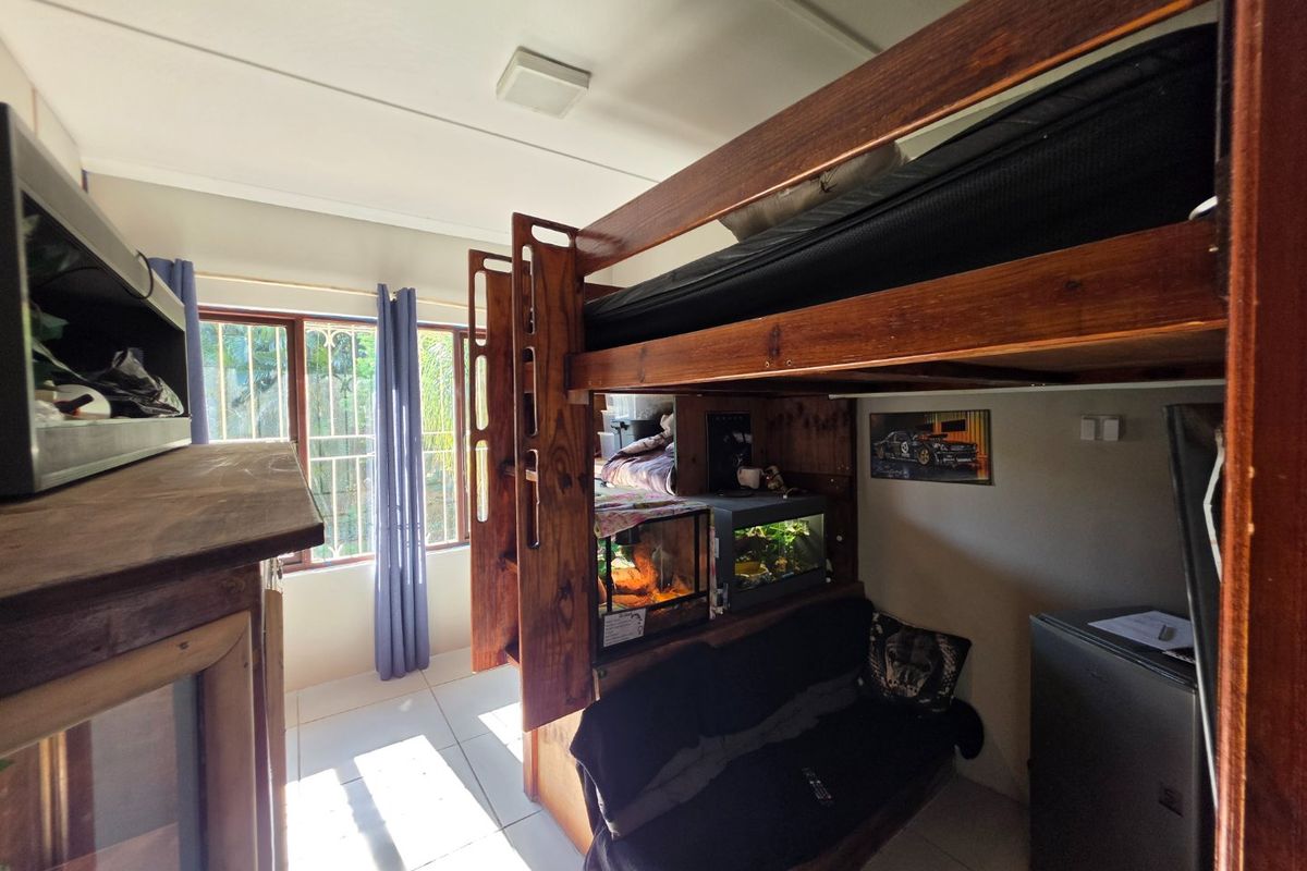 A bedroom featuring tiled flooring and windows fitted with security bars, currently utilized with a bunk bed configuration.