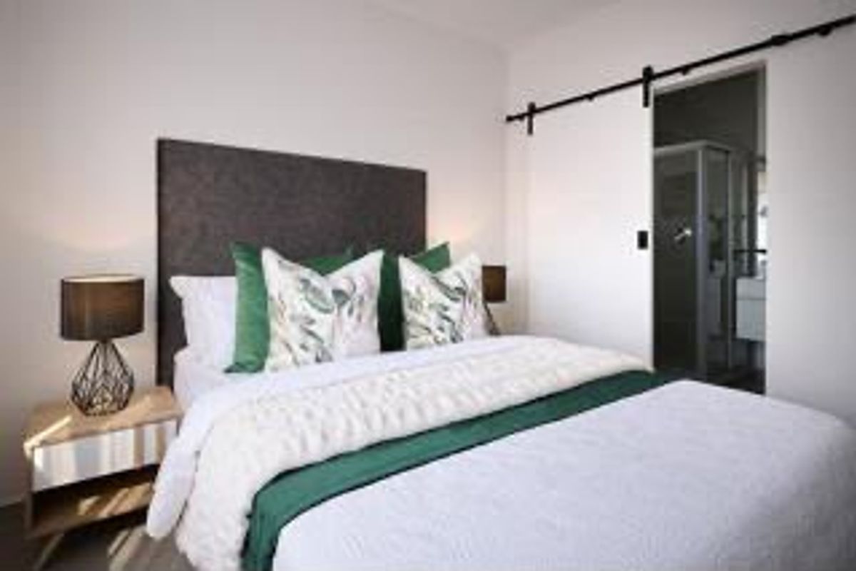 A well-presented bedroom featuring a modern sliding barn door providing direct access to an en-suite bathroom.