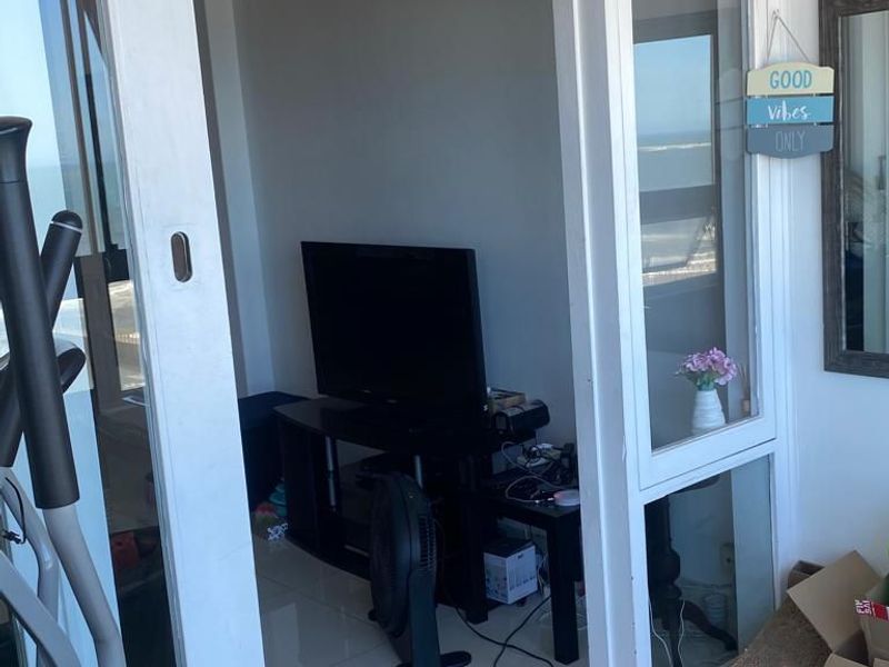 A balcony area featuring tiled flooring and sliding glass doors providing access to the interior living space.