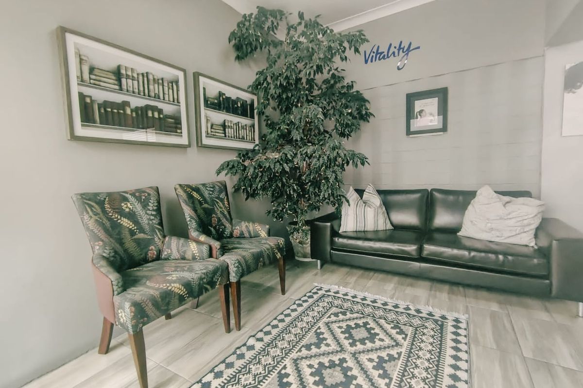 A waiting area or reception space featuring neutral wall tones, tiled flooring, and coved ceiling details, suitable for a professional commercial environment.