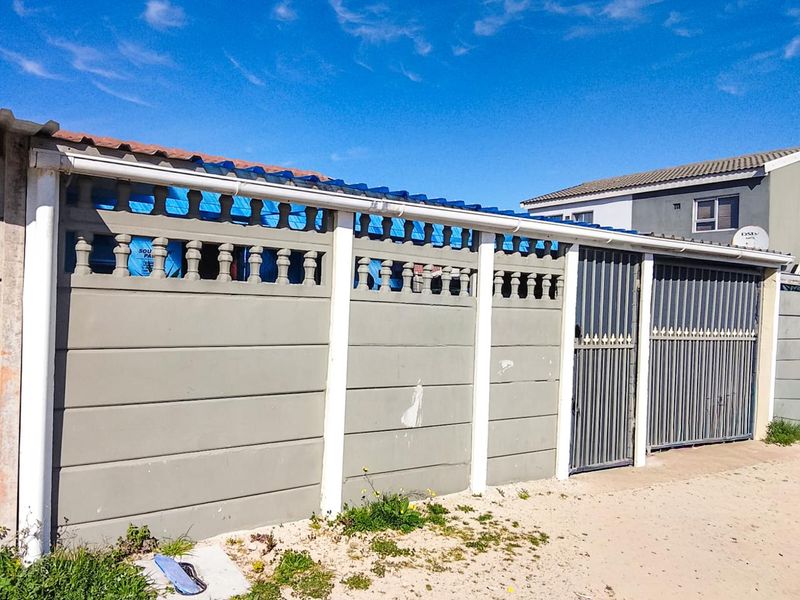 Front view of the property featuring a precast concrete boundary wall with a metal sliding gate and integrated guttering system.