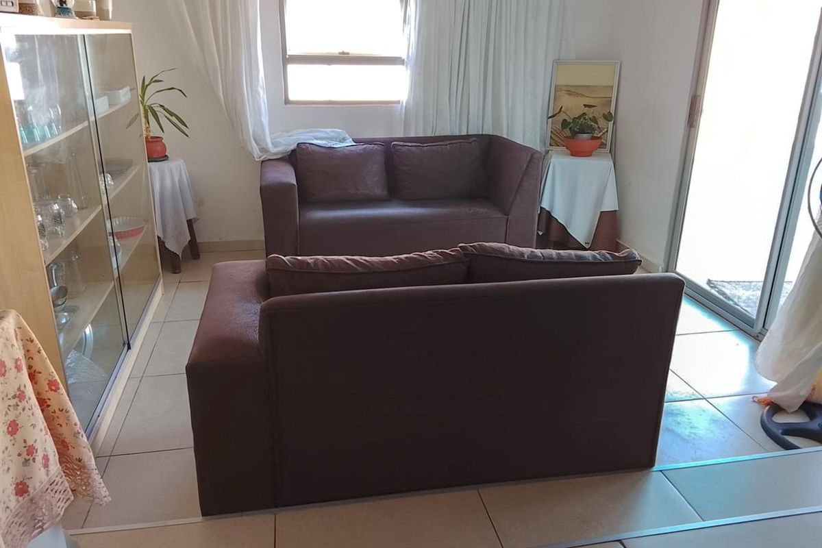 A living room area featuring tiled flooring and a sliding glass door providing access to the exterior.