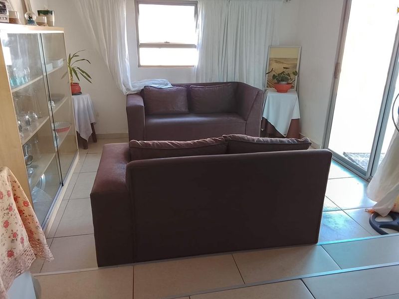 A living room area featuring tiled flooring and a sliding glass door providing access to the exterior.