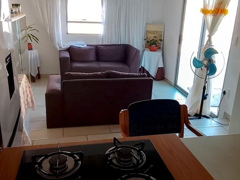 Open plan living area featuring a built-in gas hob, tiled flooring, and sliding glass doors leading to the exterior.