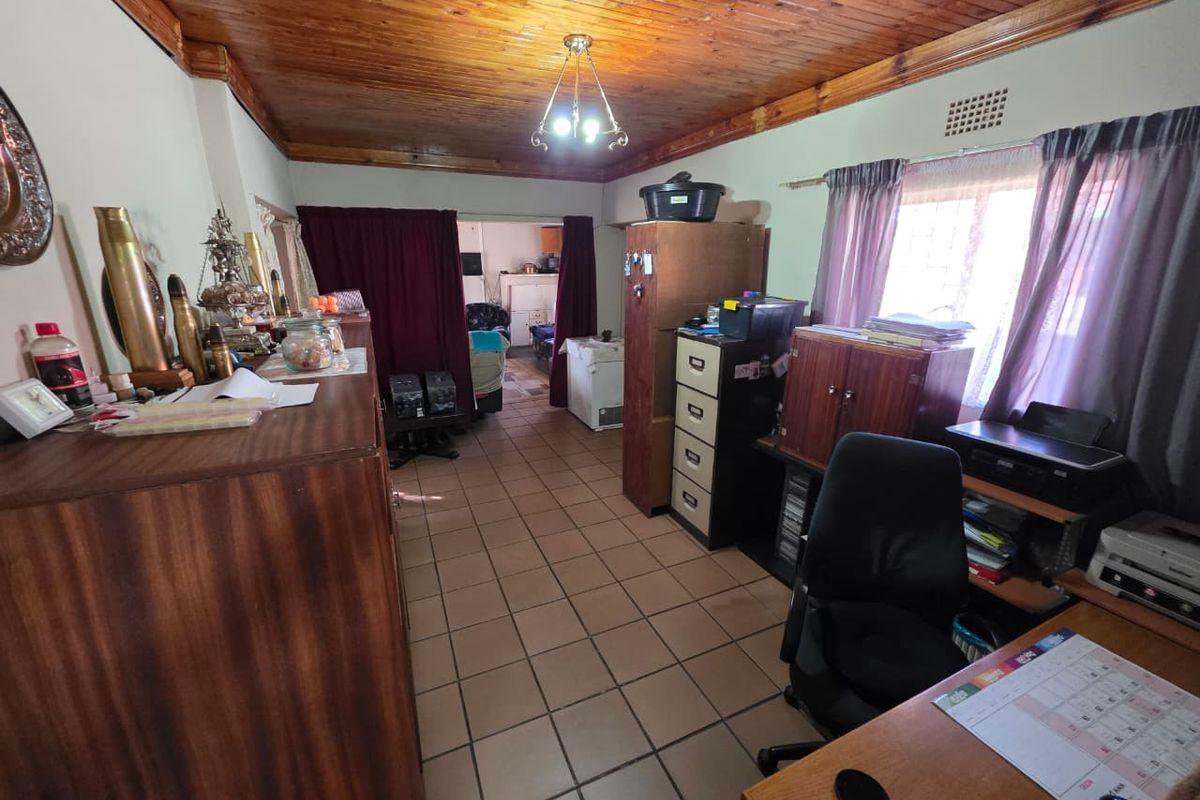 A living area featuring ceramic floor tiles and a timber tongue and groove ceiling, providing a functional space with potential for modernization.