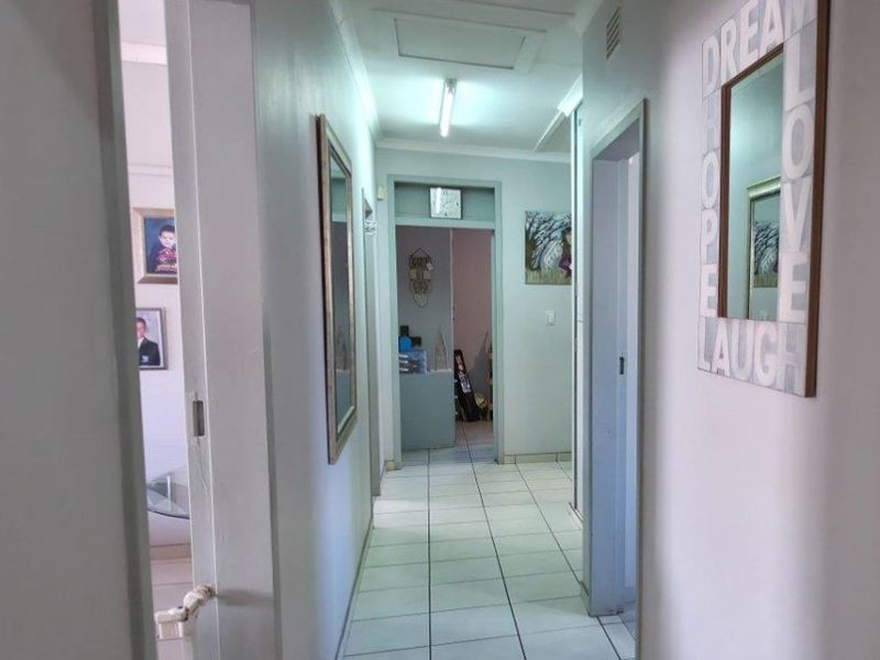 A functional hallway featuring tiled flooring and direct access to multiple rooms, providing a central circulation space within the home.