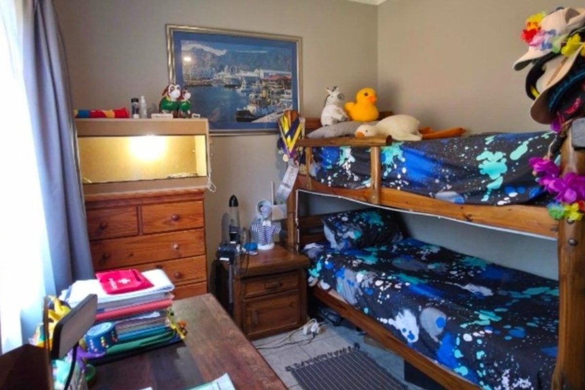 A functional bedroom featuring tiled flooring and neutral wall tones, currently utilized as a children's room.