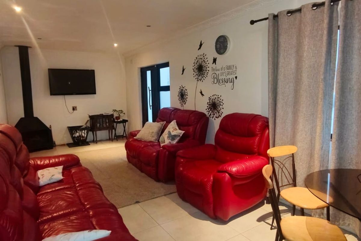 A living room featuring tiled flooring, a freestanding fireplace, and access to an outdoor area via a sliding door.