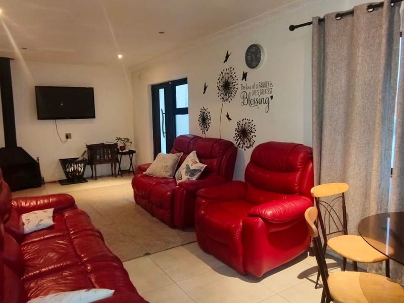 A living room featuring tiled flooring, a freestanding fireplace, and access to an outdoor area via a sliding door.