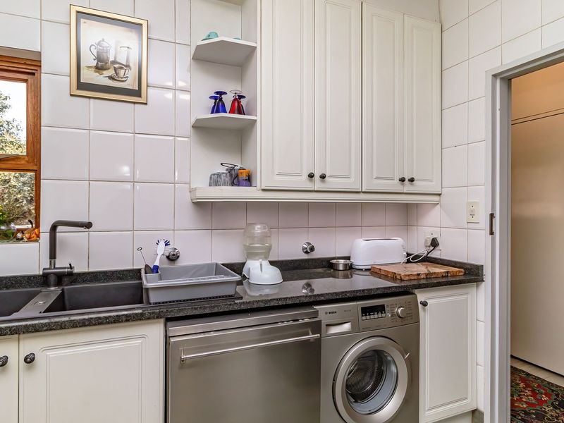 Functional scullery featuring granite countertops, double basin sink, tiled splashback, and integrated laundry and dishwashing appliances.