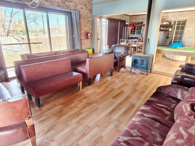 Spacious open-plan living area featuring exposed brick walls, a wood-burning fireplace, and large sliding glass doors providing ample natural light.