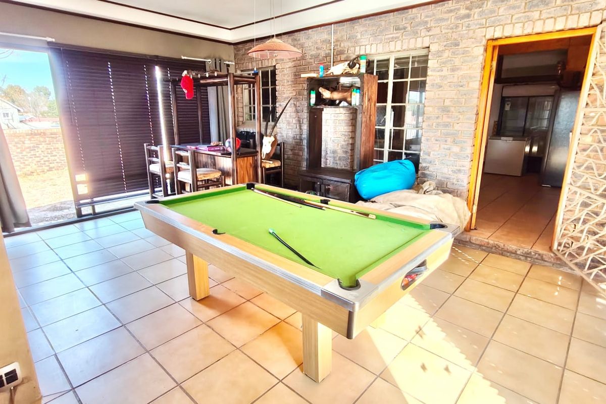 Spacious living area featuring exposed brick walls, ceramic tiled flooring, and large sliding glass doors providing access to the exterior.