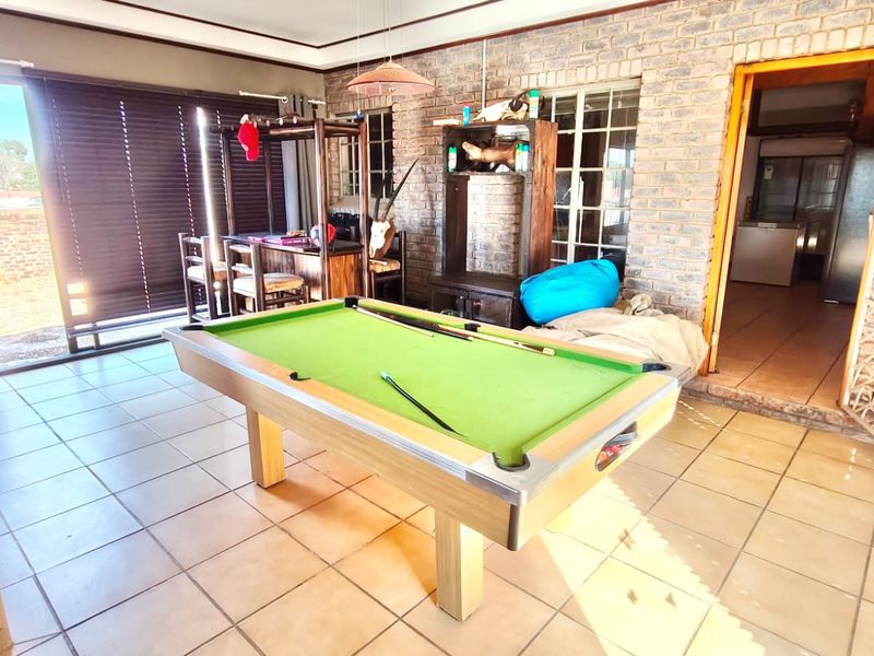 Spacious living area featuring exposed brick walls, ceramic tiled flooring, and large sliding glass doors providing access to the exterior.