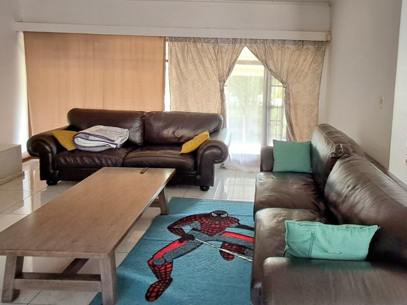 A living room featuring tiled flooring and a sliding glass door providing access to the exterior.
