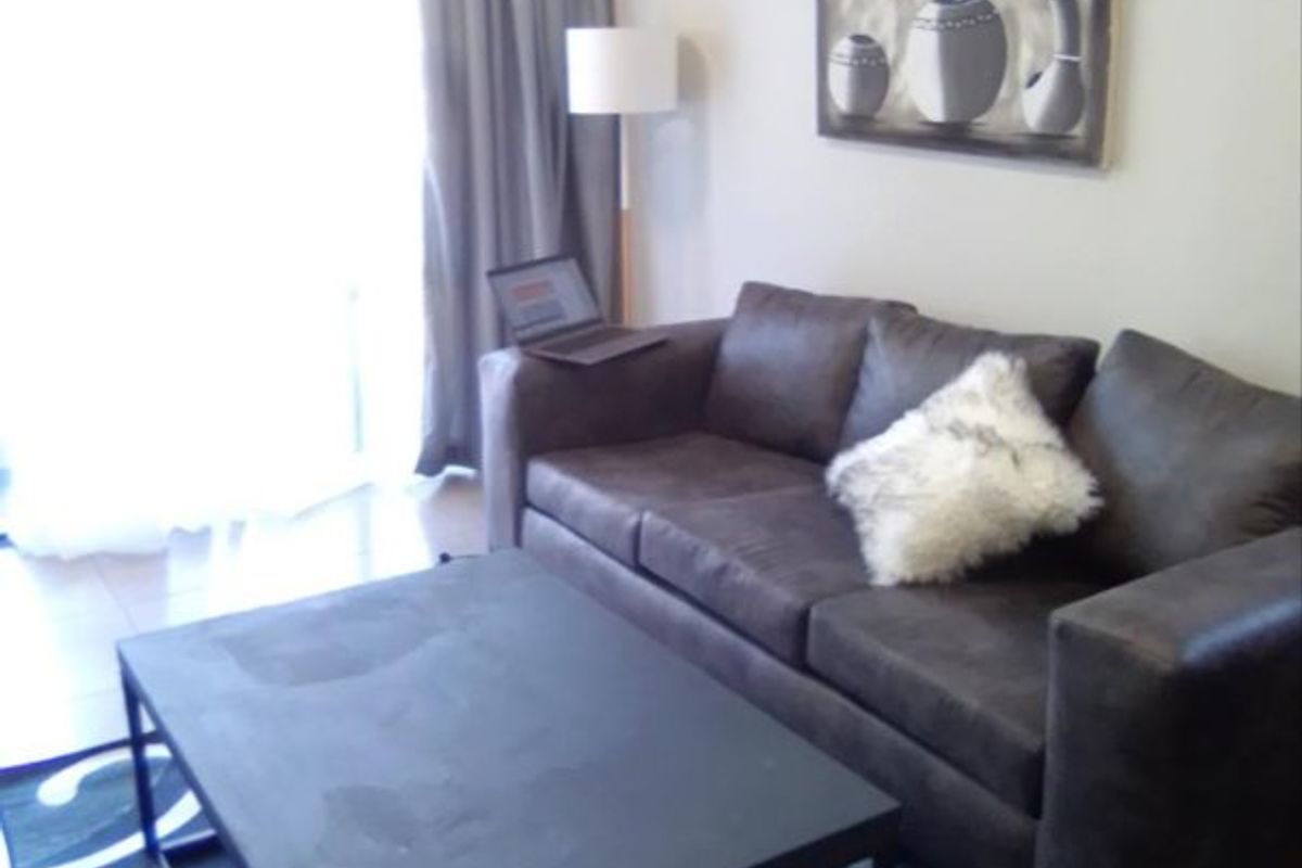 A living room area featuring tiled flooring and a sliding glass door providing natural light.